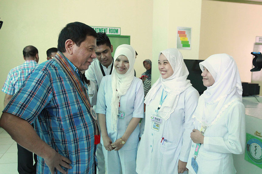 President Rodrigo Roa Duterte shares a light moment with the nurses who were tasked to take care of the wounded soldiers during his visit at Camp Teodulfo Bautista in Sukuran, Sulu on November 25. ACE MORANDANTE/Presidential Photo