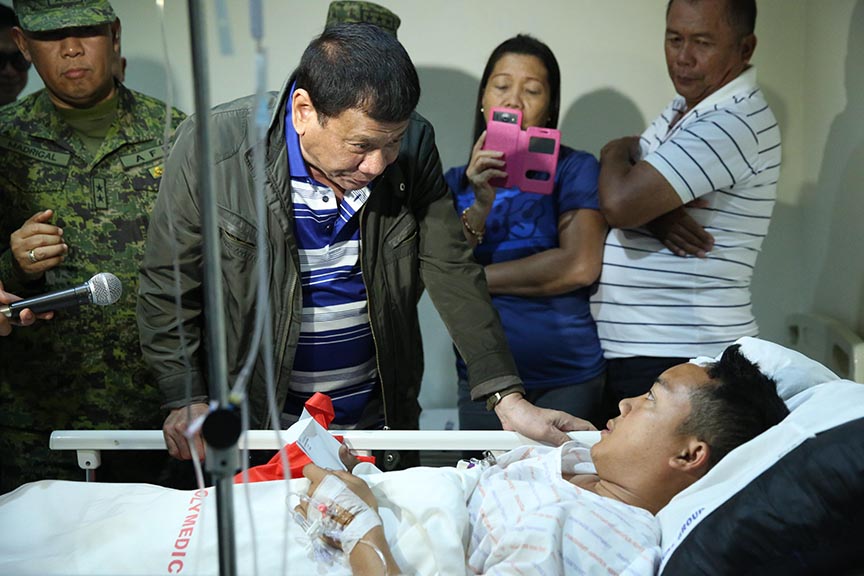 President Rodrigo Roa Duterte checks the condition of one of the five members comprising the Presidential advance party who were wounded in action during his visit to the Polymedic Medical Plaza in Kauswagan, Cagayan de Oro City on November 30, 2016. KARL NORMAN ALONZO/Presidential Photo