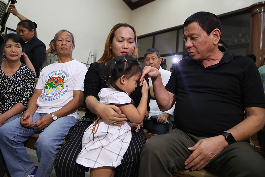 President Rodrigo Duterte offers his hand as Esther May, daughter of the late Captain Clinton Capio shows a gesture of respect during his wake visit at the Libingan ng mga Bayani in Fort Bonifacio on January 16, 2017. KING RODRIGUEZ/ Presidential Photos
