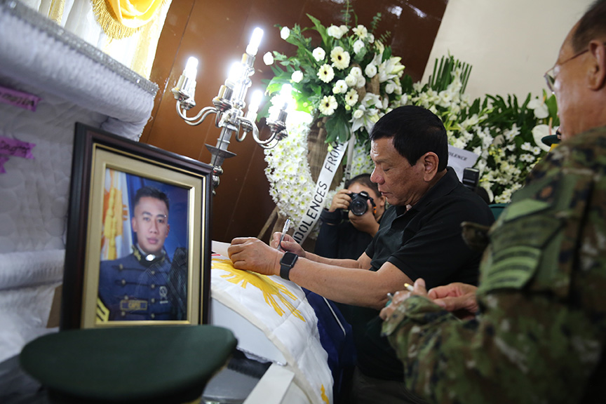 President Rodrigo Duterte makes a note to one of the official of the Armed Forces of the Philippines which he asked to hand over to him immediately the promotion of the late Capt. Clinton Capio while visiting the wake of the fallen soldier inside the mortuary at the Libingan ng mga Bayani in Fort Bonifacio on January 16, 2017. KING RODRIGUEZ/ Presidential Photos