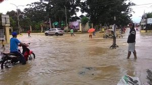 Local folks wade through the floodwaters in the town proper of Kapalong, Davao del Norte on Tuesday morning. Continuous rains in the region have inundate various parts of the province. Photo courtesy of Phoebie Graza