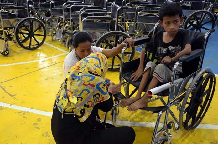 MAITUM, Sarangani (January 7, 2017) – A Department of Heath personnel assists a parent of one of the beneficiaries of the Handog Pasasalamat of the provincial government and the local government unit of Maitum Friday, January 6. The beneficiaries of 45 wheelchairs were persons with disability (PWDs) and senior citizens. (John James I. Doctor/MAITUM INFORMATION OFFICE)