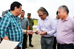 President Rodrigo Roa Duterte hands a check worth P192.5-million to Southern Philippines Medical Center (SPMC) Chief Dr. Leopoldo Vega at the Tactical Operations Group (TOG)-11 in Sasa, Davao City on March 3, 2017. The check is the first tranche for the P385-million needed to improve the facilities of SPMC. RENE LUMAWAG/Presidential Photo