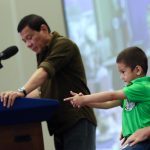 POSING LIKE A PRO: Stingray, the grandson of President Rodrigo Duterte (in green polo) pose like enjoying his fingers holding a gun while his grandfather talks about imposing stiffer government regulations to gun buyers.-PHOTO: PPD