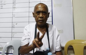 Cayamora Maute, father of the Maute brothers, flashes a peace sign while inside the Davao City Police Office on 6 June 2017. Cayamora was arrested at the Sirawan, Toril checkpoint of Task Force Davao. Newsline Photo