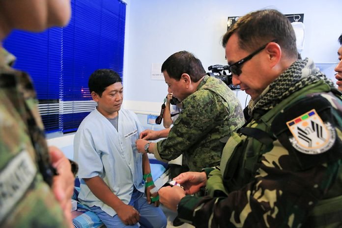 President Rodrigo Roa Duterte awards a wounded personnel medal to Staff Sergeant Gerry Torsal during the President's visit to Camp Panacan Station Hospital in Davao City on July 20, 2017. Torsal was one of the Presidential Security Group (PSG) personnel wounded in an encounter against the New People's Army in Arakan, North Cotabato on July 19. ALBERT ALCAIN/PRESIDENTIAL PHOTO
